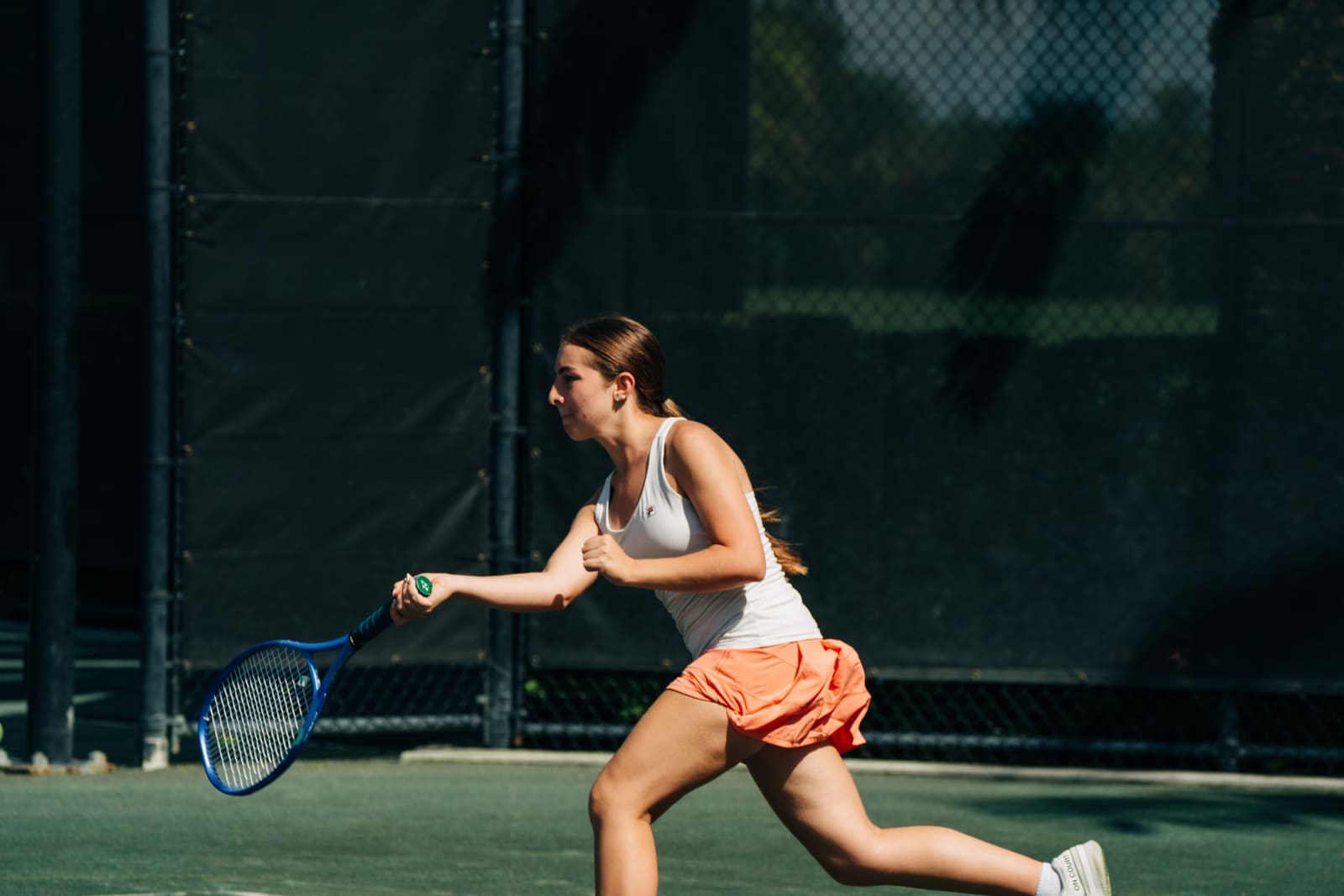 Older junior stretching into a forehand