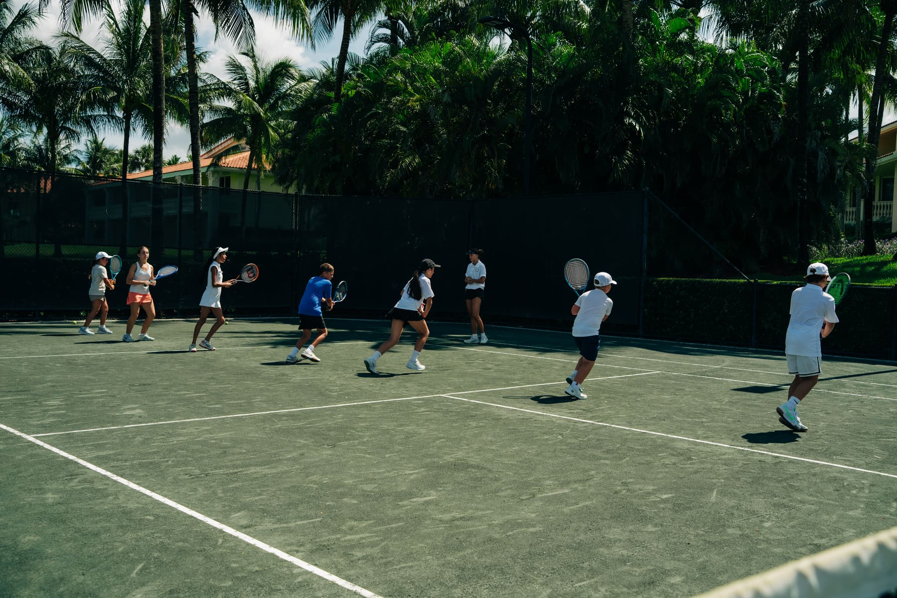 Junior group class lined up on the green courts at Italian Tennis Academy, Doral